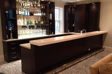 Photo of a transitional u-shaped home bar in Chicago with shaker cabinets and dark wood cabinets.