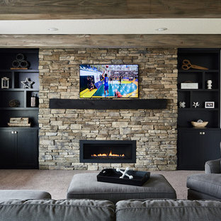 Design ideas for a medium sized industrial walk-out basement in Minneapolis with grey walls, carpet, a standard fireplace, a stone fireplace surround and beige floors.