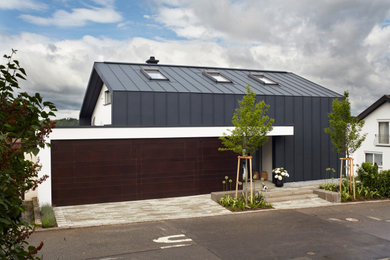 Foto de fachada de casa gris y gris minimalista de tres plantas con revestimiento de metal, tejado a dos aguas y tejado de metal