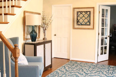 Example of a small transitional medium tone wood floor foyer design in Cincinnati with yellow walls