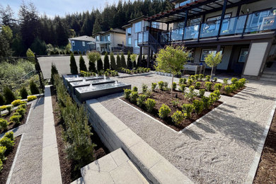 Photo of a mid-sized modern full sun hillside gravel landscaping in Vancouver.
