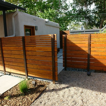 Steel and wood private fence separating living space from hot tub area.