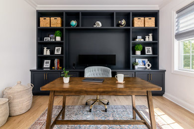 Diseño de despacho tradicional renovado de tamaño medio con paredes grises, suelo de madera clara, escritorio empotrado y suelo marrón