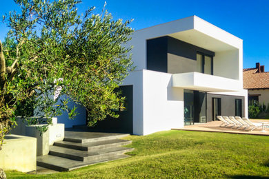 Imagen de fachada de casa minimalista de tamaño medio de dos plantas con revestimientos combinados