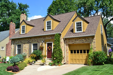 This is an example of a traditional two-storey yellow exterior in Minneapolis with concrete fiberboard siding.