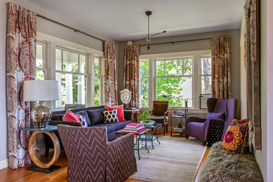 Example of a mid-sized eclectic enclosed medium tone wood floor and brown floor living room design in Austin with gray walls, no fireplace and no tv