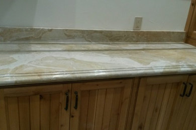 Example of a mid-sized galley laundry room design in Other with marble countertops