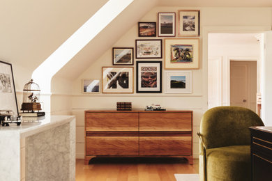 Ejemplo de despacho abovedado moderno de tamaño medio con paredes beige, suelo de madera clara, escritorio independiente y suelo marrón