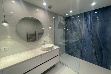 シカゴにあるモダンスタイルのおしゃれなバスルーム (浴槽なし) (白いキャビネット、オープン型シャワー、壁掛け式トイレ、白い洗面カウンター、洗面台1つ、フローティング洗面台) の写真
