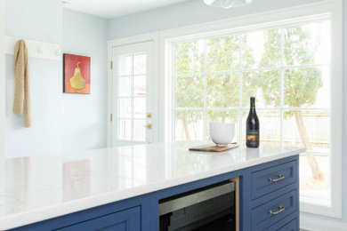 Mid-sized transitional ceramic tile and gray floor eat-in kitchen photo in Other with an undermount sink, recessed-panel cabinets, white cabinets, quartz countertops, white backsplash, quartz backsplash, stainless steel appliances, an island and white countertops