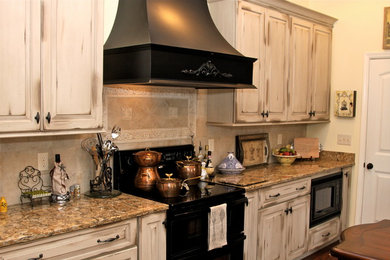 Inspiration for a large cottage dark wood floor eat-in kitchen remodel in Nashville with an undermount sink, raised-panel cabinets, distressed cabinets, quartz countertops, beige backsplash, porcelain backsplash, black appliances and an island
