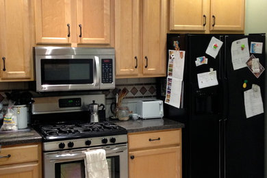 Example of a mid-sized eclectic light wood floor eat-in kitchen design in Jacksonville with an undermount sink, flat-panel cabinets, light wood cabinets, granite countertops, beige backsplash, stainless steel appliances and a peninsula