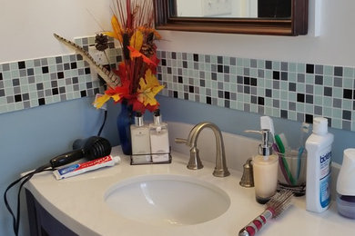 Alcove shower - small eclectic 3/4 multicolored tile and glass tile porcelain tile alcove shower idea in Richmond with shaker cabinets, medium tone wood cabinets, a two-piece toilet, blue walls, an undermount sink and quartz countertops