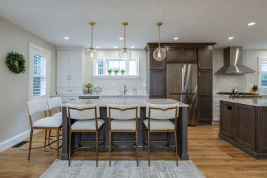 Inspiration for a single-wall medium tone wood floor kitchen remodel in Boston with an undermount sink, shaker cabinets, white cabinets and two islands