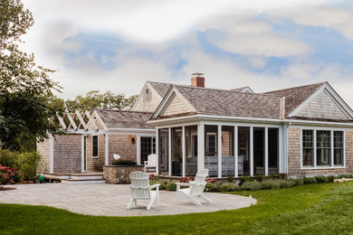 Example of a large beach style brown one-story wood exterior home design in Boston with a shingle roof