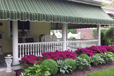 Photo of a large beach style front yard verandah in Philadelphia with an awning.
