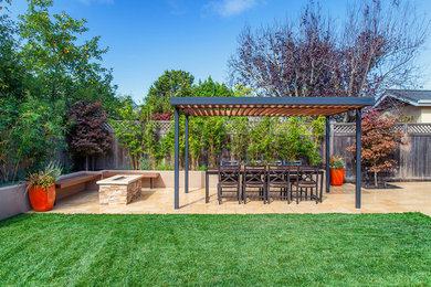 This is an example of a large traditional backyard patio in San Francisco with a fire feature, brick pavers and a pergola.