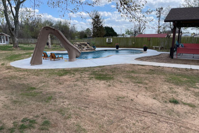 Water slide - mid-sized tropical backyard custom-shaped natural water slide idea in Oklahoma City