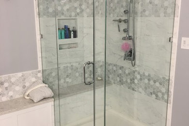 Inspiration for a large transitional master gray tile, white tile and porcelain tile porcelain tile and gray floor bathroom remodel in Baltimore with shaker cabinets, white cabinets, purple walls, an undermount sink, quartz countertops, a hinged shower door and white countertops