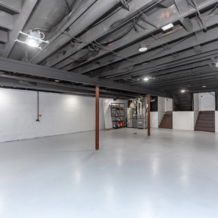 Photo of an expansive traditional look-out basement in Kansas City with white walls, concrete flooring, no fireplace and grey floors.