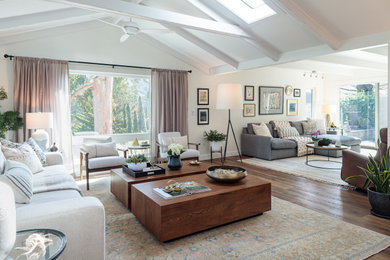 Expansive retro open plan living room in San Francisco with laminate floors, a wall mounted tv and a vaulted ceiling.