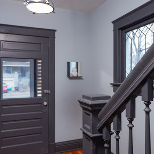 На фото: маленькая входная дверь в современном стиле с серыми стенами, одностворчатой входной дверью, серой входной дверью, полом из бамбука и коричневым полом с