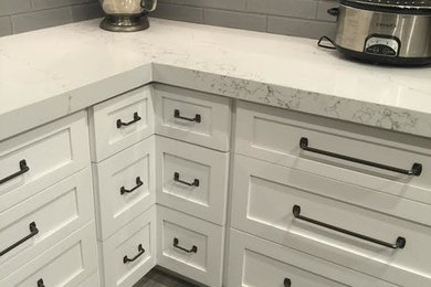 Mid-sized transitional l-shaped kitchen in Miami with shaker cabinets, white cabinets, quartzite benchtops, grey splashback, glass tile splashback, stainless steel appliances and with island.