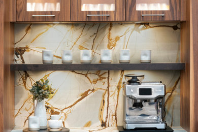 Example of a large minimalist u-shaped light wood floor, brown floor and shiplap ceiling open concept kitchen design in Oklahoma City with an undermount sink, flat-panel cabinets, medium tone wood cabinets, quartzite countertops, blue backsplash, stone slab backsplash, paneled appliances, an island and blue countertops