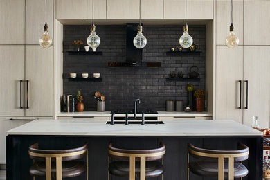 Trendy galley medium tone wood floor and gray floor kitchen photo in Atlanta with an undermount sink, flat-panel cabinets, light wood cabinets, black backsplash, paneled appliances, an island and white countertops