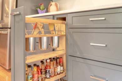 Inspiration for a mid-sized contemporary u-shaped light wood floor and brown floor home bar remodel in Boston with an integrated sink, white backsplash, subway tile backsplash and yellow countertops