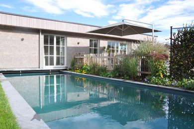 Kleiner Moderner Infinity-Pool auf dem Dach in individueller Form mit Pool-Gartenbau und Natursteinplatten in Sonstige
