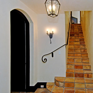 Design ideas for a mediterranean straight metal railing staircase in Los Angeles with terracotta treads and terracotta risers.