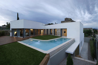 Photo of a mid-sized modern two-storey stucco white exterior in Barcelona with a flat roof.
