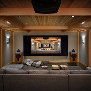 Inspiration for a rustic enclosed home cinema in Seattle with grey walls, carpet, grey floors and a projector screen.