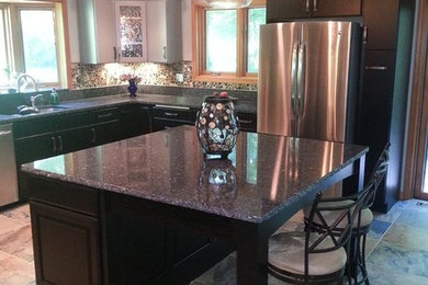Eat-in kitchen - mid-sized transitional u-shaped porcelain tile eat-in kitchen idea in Cleveland with an undermount sink, flat-panel cabinets, black cabinets, quartzite countertops, brown backsplash, stone tile backsplash, stainless steel appliances and an island