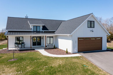 Modelo de fachada de casa blanca y gris campestre de tamaño medio con revestimiento de vinilo, tejado a dos aguas, tejado de varios materiales y panel y listón