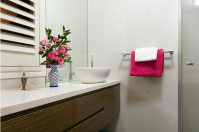 Design ideas for a mid-sized modern bathroom in Canberra - Queanbeyan with furniture-like cabinets, medium wood cabinets, white tile, ceramic tile, porcelain floors, engineered quartz benchtops and beige benchtops.