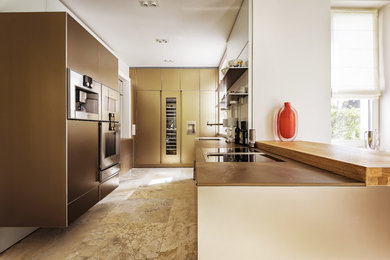 Photo of a large u-shaped open plan kitchen in Berlin with an undermount sink, flat-panel cabinets, beige cabinets, limestone benchtops, white splashback, glass sheet splashback, stainless steel appliances, limestone floors, a peninsula, beige floor and brown benchtop.