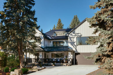 Modelo de fachada de casa blanca y negra contemporánea de dos plantas con revestimientos combinados, tejado de metal y panel y listón