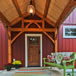 ボストンの片開きドアカントリー風おしゃれな玄関ドア (赤い壁、淡色無垢フローリング、木目調のドア) の写真