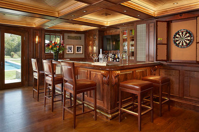 Large elegant u-shaped medium tone wood floor seated home bar photo in San Francisco with glass-front cabinets, medium tone wood cabinets and wood countertops
