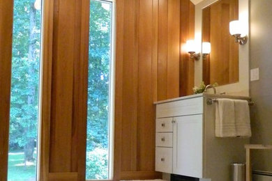 Example of a large trendy master ceramic tile ceramic tile corner shower design in Philadelphia with flat-panel cabinets, white cabinets and gray walls