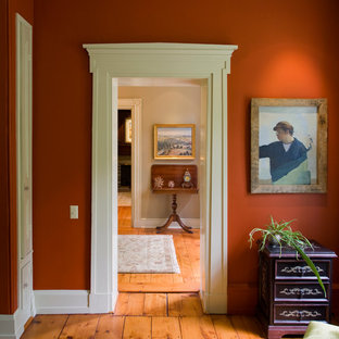 Inspiration för klassiska hallar, med röda väggar, mellanmörkt trägolv och orange golv