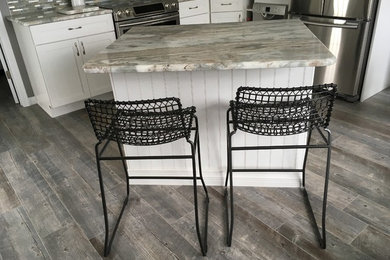 Inspiration for a mid-sized transitional l-shaped medium tone wood floor eat-in kitchen remodel in New York with an undermount sink, recessed-panel cabinets, white cabinets, granite countertops, gray backsplash, matchstick tile backsplash, stainless steel appliances and an island