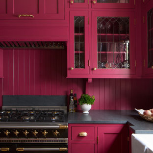 Inspiration for a small traditional l-shaped separate kitchen in Seattle with a farmhouse sink, shaker cabinets, pink cabinets, granite benchtops, pink splashback, timber splashback, panelled appliances, light hardwood floors, no island, brown floor and black benchtop.