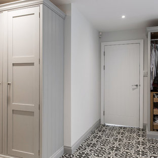 ケントの巨大なコンテンポラリースタイルのおしゃれな家事室 (シェーカースタイル扉のキャビネット、グレーのキャビネット、セラミックタイルの床、左右配置の洗濯機・乾燥機、シングルシンク、ラミネートカウンター、グレーの壁、黄色い床、グレーのキッチンカウンター) の写真