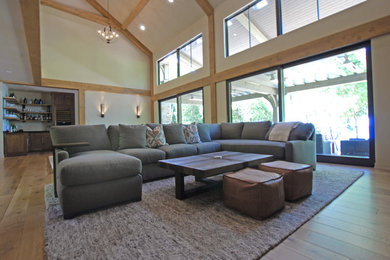 Living room - large modern open concept medium tone wood floor living room idea in Milwaukee with white walls