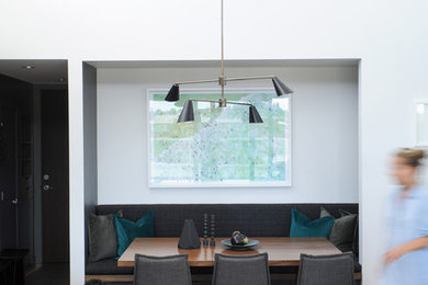 Small contemporary open plan dining in Vancouver with white walls and medium hardwood floors.