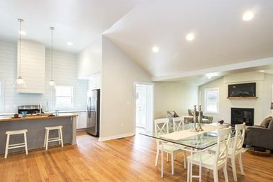 Inspiration for a mid-sized transitional light wood floor great room remodel in Raleigh with white walls and a standard fireplace