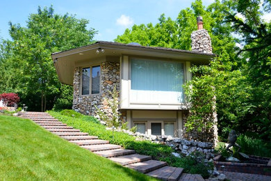 Inspiration for a large timeless brown two-story stone flat roof remodel in Indianapolis